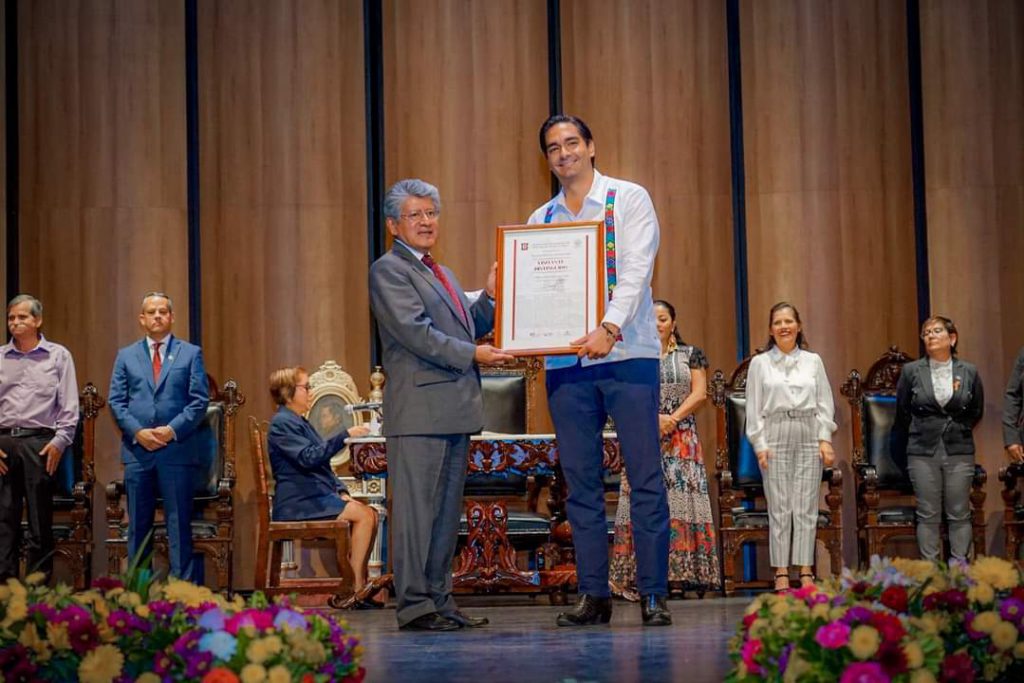 Neri Martínez holding a certificate